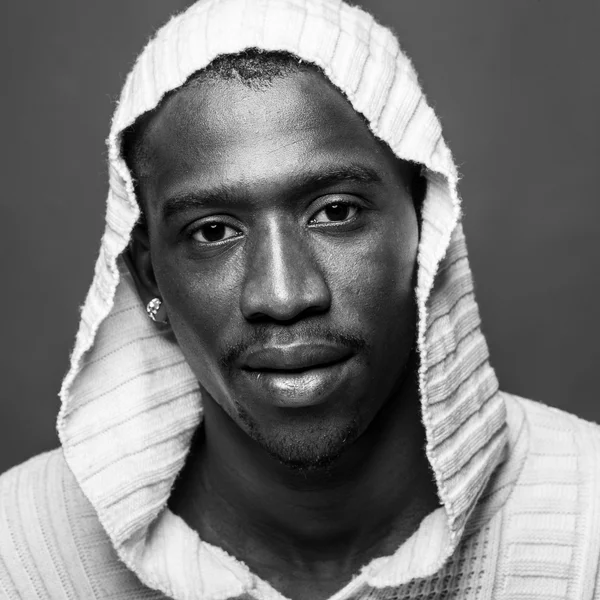 Young african man close up portrait against dark background. Black and white image. — Stock Photo, Image