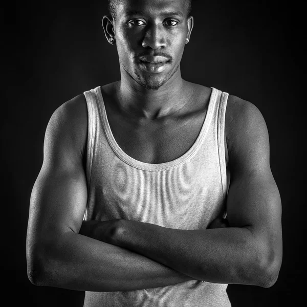 Young african man close up portrait against dark background. Black and white image. — Stock Photo, Image