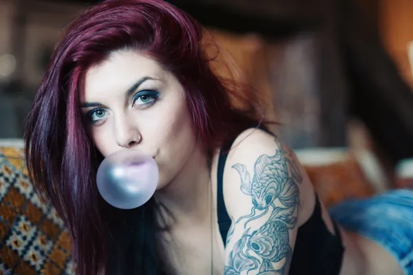 Sensuell porträtt av vackra tatuerade röda huvud flicka med tuggummi. — Stockfoto