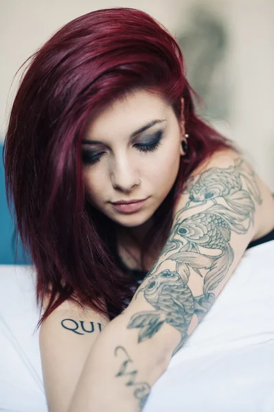 Sensual retrato de hermosa chica con tatuaje acostado en la cama . —  Fotos de Stock