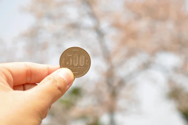 Una mano sostiene moneda de 500 yenes — Foto de Stock