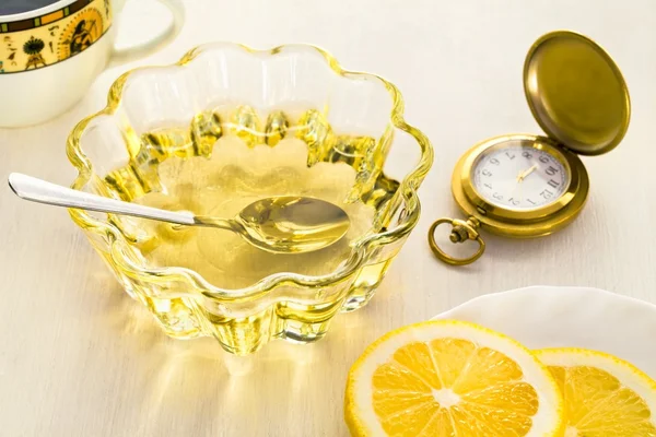 Две желтые чашки лимона и меда с часами — стоковое фото