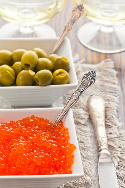 Olives and red caviar are in two white bowls — Stock Photo, Image