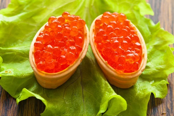 Two caviar, scattered in baked waffle capitula on green leaf salad — Stock Photo, Image