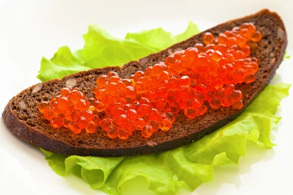 Caviar, está en el pan en una ensalada de hojas verdes —  Fotos de Stock