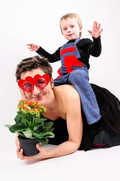 Woman with a flower and her son — Stock Photo, Image