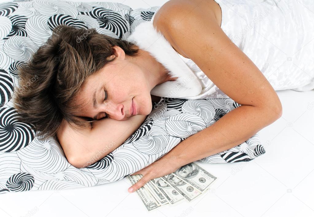 Sleeping woman with money under the pillow
