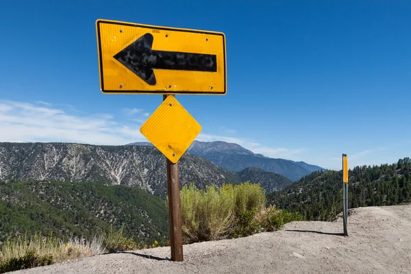 Arrow sign on top of high altitude cliff Stock Image