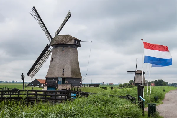 Windmills in marsh landscape with Dutch flags Stock Photo