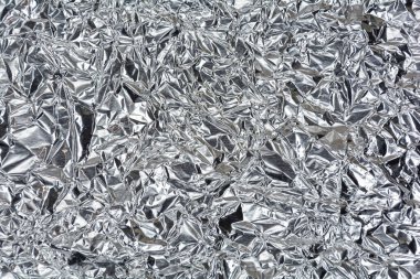 Arka planda parlak bir nane yüzeyi olan gümüş folyo. Gümüş renk ve doku arkaplanı