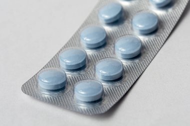 Mavi haplar yakın plan çekimde. Su toplaması için gereken vitaminler. Bağışıklık sistemini güçlendirmek için vitaminler. Tedavi ve önleme için ilaçlar.