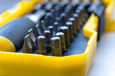 Alet takımı. İçinde metal aletler olan büyük bir kutu. Çok sayıda parçası olan bir tornavida seti. Erkek alet çantası. Parlak, gümüş metalik detaylar, ahşap bir arka planda yeşil bir kutunun içinde.