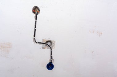 Tamamlanmamış plastik elektrik kutuları ve duvarlara kurulmuş anahtarlar.