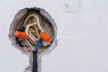 Bağlantı kutusunun kurulumu, yüksek voltaj. Beton bir duvardaki elektrik kablolarını birbirine bağlamak için yalıtımlı bir bağlantı kelepçesi ya da kablo bağlayıcı fındık kullanmak