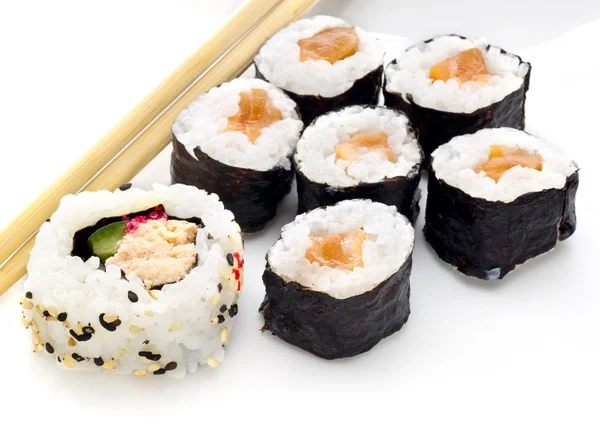 Köstliche Sushi-Rollen auf weißem Teller mit Essstäbchen — Stockfoto
