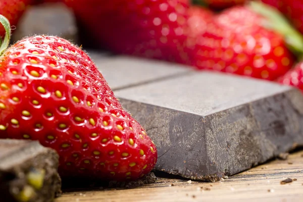 Erdbeeren rohe Schokolade auf dem Holztisch — Stockfoto