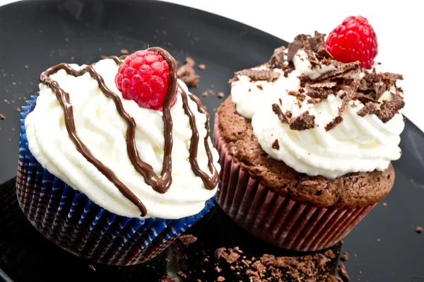 Muffins de chocolate com chantilly e framboesas — Fotografia de Stock