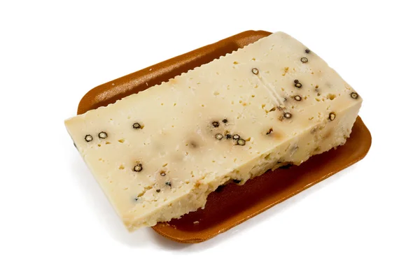 Овечий сыр с перцем в пластиковой тарелке из супермаркета — стоковое фото