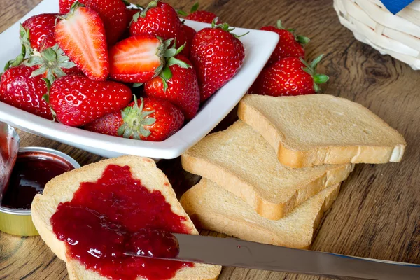 Erdbeermarmelade mit Zwieback auf Holztisch — Stockfoto