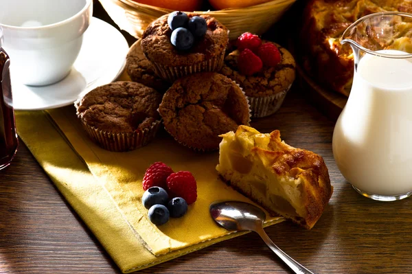 Homemade muffins and apple pie on early morning light — Stock Photo, Image