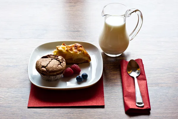 Zelfgemaakte muffins, melk en appeltaart op de vroege ochtend licht — Stockfoto