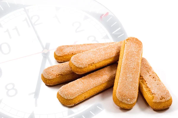 Galletas ladyfinger en el fondo del reloj —  Fotos de Stock