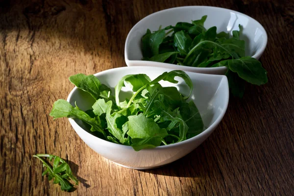 Skål med färska gröna, naturliga rucola — Stockfoto