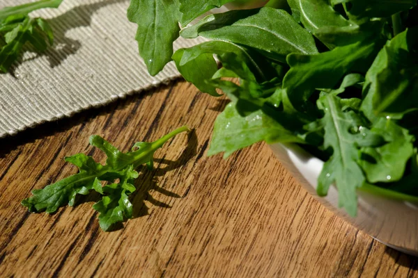 Skål med färska gröna, naturliga rucola — Stockfoto