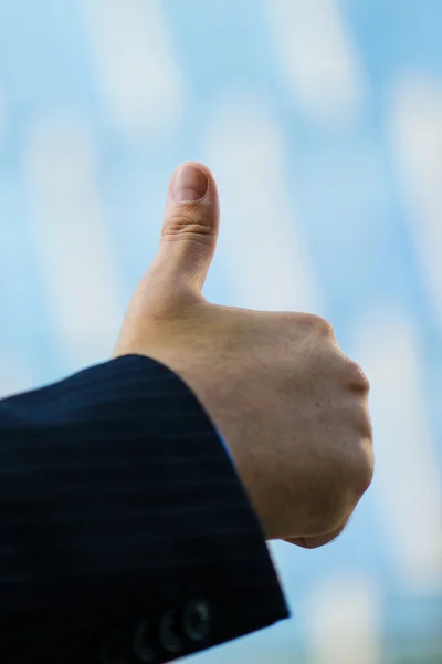 Business man hand with thumb up in citylife background — Stock Photo, Image