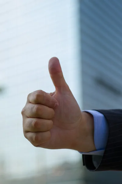 Business man hand with thumb up in citylife background — Stock Photo, Image