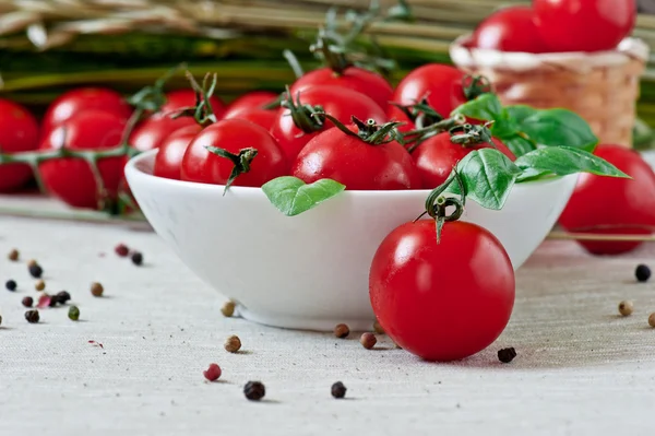 Planche à découper avec tomates et feuilles de basilic — Photo