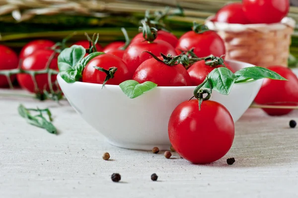Planche à découper avec tomates et feuilles de basilic — Photo