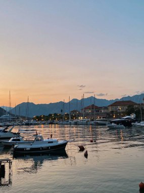 Kotor limanında tekneler ve Adriyatik denizinde akşam batımı