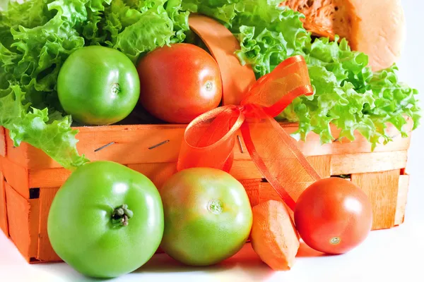 Зеленые помидоры в оранжевой корзине — стоковое фото