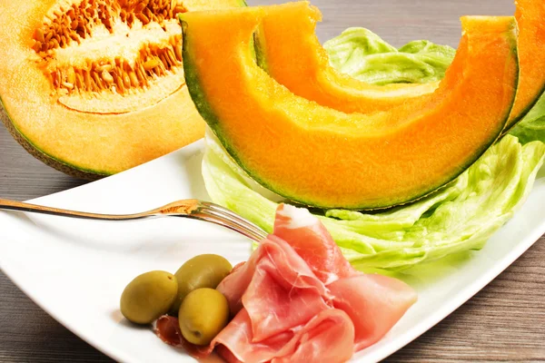 Melon with ham on the table — Stock Photo, Image