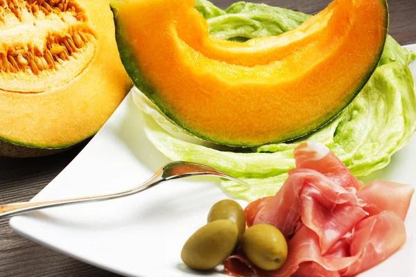 Melon with ham on the table — Stock Photo, Image