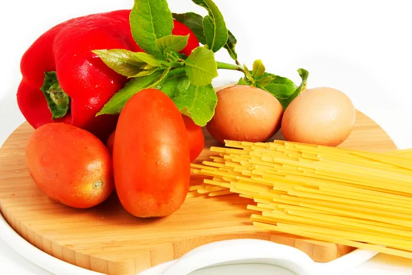 Spaghetti, pasta in tavola con uova, pomodori e peperoni su fondo bianco — Foto Stock