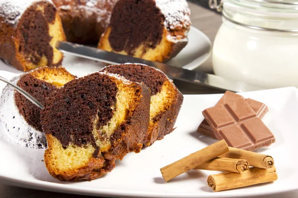 Schokoladenkuchen mit Zimt und Joghurt auf dem Tisch — Stockfoto