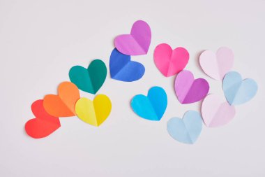 Gri arkaplanda gökkuşağı renkli kağıt kalpler, gurur konsepti üst görünüm kopya alanı maketi
