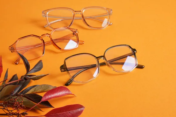 Mehrere Verschiedene Trendige Mode Brille Nad Rote Herbstblätter Auf Orangefarbenem — Stockfoto