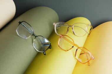 yuvarlanmış kağıt, geometrik arkaplan, yeşil renkler, koyu yeşil arkaplan, görüş testi konsepti, optik mağazasında güzel moda aksesuarları