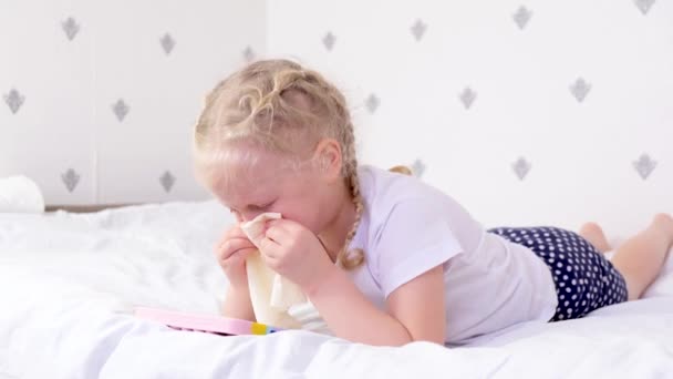 Girl blows her nose and plays with smart phone — Stock Video
