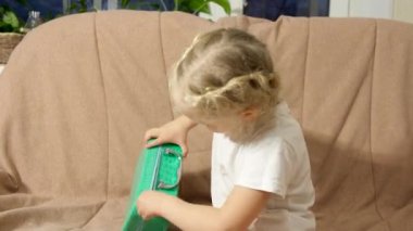 Küçük kız hediye açar, makyaj seti. Yüzünü kanepeye yapıştır..