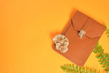 telefon ve cüzdan çantası ve turuncu arka planda ağaç mantarı, mantar miselyumundan yapılmış eko vegan deri fotokopi alanı