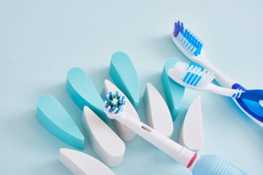 Mavi arka planda elektrikli ve plastik diş fırçaları, diş fırçalarının ağız boşluğunu temizlemede ve çevre dostu çalışmada daha etkilidir.