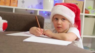 Noel Baba 'ya, Noel Baba' ya, Noel Arifesi 'ne, Noel hazırlıklarına, Noel havasına ve dekorasyona mektup yazan 5-6 yaşlarında beyaz bir kız.