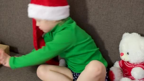 Yaşlarında Noel Baba Şapkalı Tatlı Beyaz Kız Noel Arifesinde Kanepede — Stok video