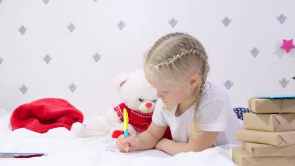 Милая Кавказская Девочка Лет Светлыми Светлыми Волосами Пишет Письмо Санта — стоковое видео