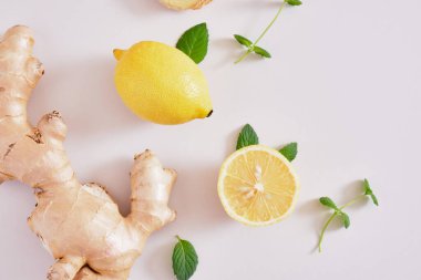 Gri arka planda zencefil kökü, nane yaprağı ve limon, zencefilin sağlık faydaları, bağışıklık alanı için doğal içecek