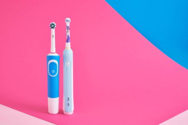 parlak geometrik pembe ve mavi arka planda elektrikli mavi diş fırçaları ağız hijyen konseptini kopyala alan ağız hijyen konseptini